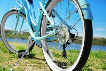 Blue bicycle standing on grass near river