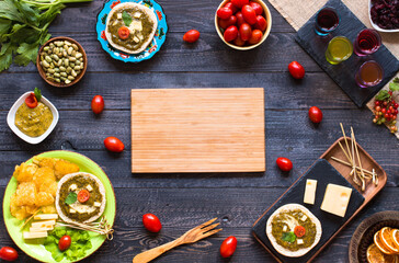 tasty and delicious bruschetta with avocado, tomatoes, cheese, herbs, chips and liquor, on a wooden background.