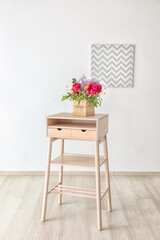 Gift box with beautiful floral composition of different fragrant flowers on table in light room