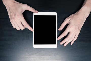Close up of Male hands using tablet on the table.