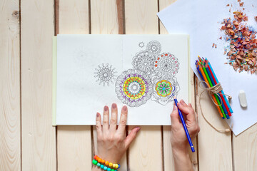 Bright ornamental flower mandala painted colour pencils. View from above.