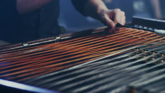 Cimbalom string music instrument. Close up of cimbalom string. Male musician playing cimbalom music. String music instrument. National string instrument. Hammered dulcimer