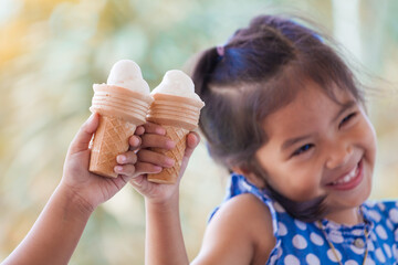 Two asian little girls  holding melting ice cream waffle cone together in vintage color tone