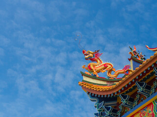 Golden Dragon sculpture on the roof with beautiful color and blue sky background