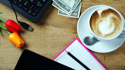 Hot cappuccino or latte art coffee. A cup of coffee on the wooden table. Morning breakfast with coffee. Latte art created by pouring steamed milk.