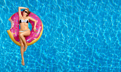 Woman in bikini on the inflatable mattress in the swimming pool. - obrazy, fototapety, plakaty