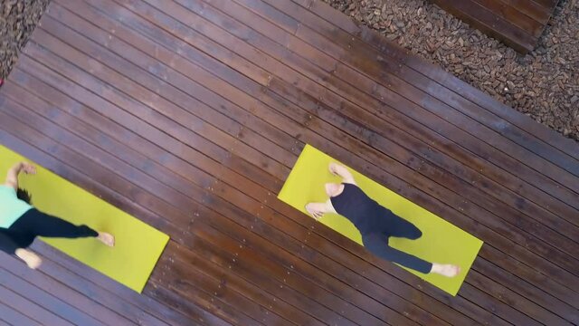 Drone footage of a group of people standing in the one-legged wheel pose