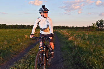 Plakat cyclist rides a bicycle in a field