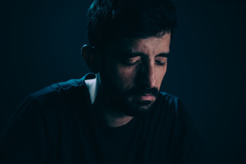 Close up of sad man in dark room. Depression and anxiety disorder concept