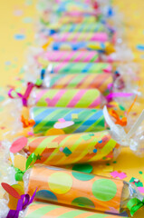 Celebratory crackers with confetti on a yellow background