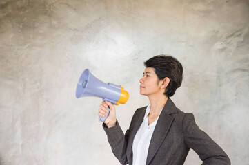 Woman holding Megaphone in  hand on gray background .
