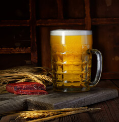 Beer in mug on wooden table near brick wall
