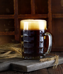 Beer in mug on wooden table near brick wall