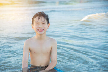 Young asian boy smiling in the sea