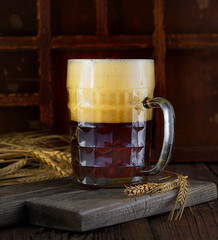 Beer in mug on wooden table near brick wall