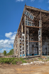 A dilapidated building, concrete supports and floors overlap partially intact