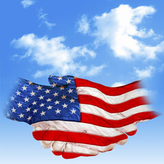 Hands, touching, wrapped with American flag, isolated against the cloudy blue sky