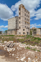 A dilapidated building for industrial use among construction debris