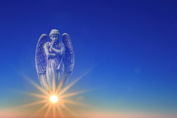 Angel over blue sky with rays of sun light with copy space