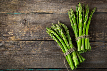 wooden bacckground with bunches of fresh green asparagus - 157614778
