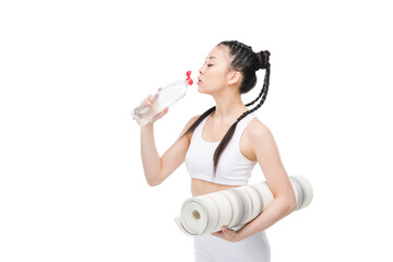 Attractive young asian woman holding yoga mat and drinking water from bottle