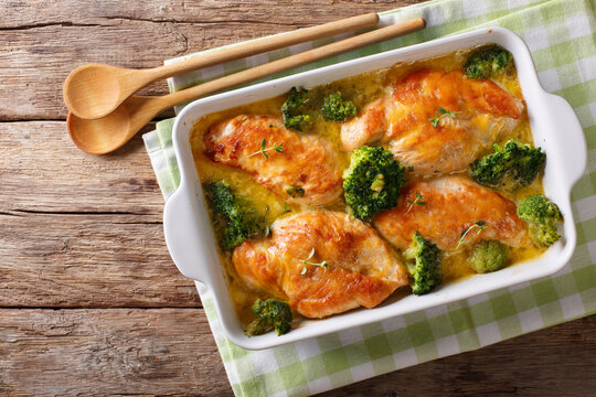 Chicken fillet baked with broccoli in cheese sauce close-up on a table. Horizontal top view