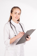 Female doctor with stethoscope writing to clipboard.