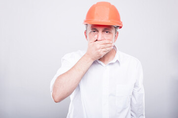 Portrait of contractor wearing hardhat covering his mouth