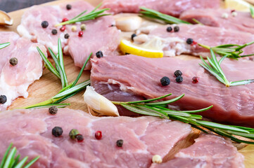 Raw flat meat for steak (chop) with spices on a cutting board.  Close up