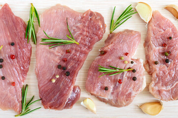 Raw flat meat for steak (chop) with spices on a light background. Top view.