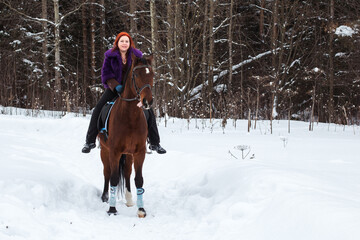 Fototapeta na wymiar Woman with red hair and big horse outdoor in winter