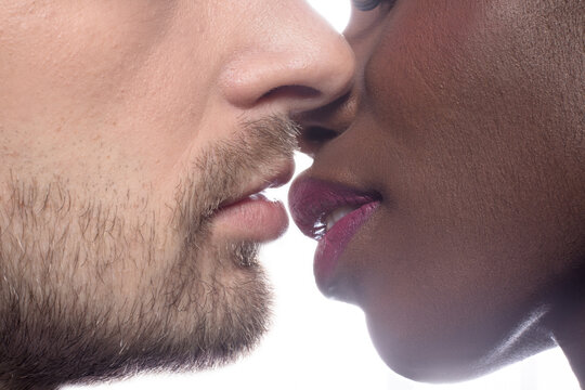 Multi ethnic kissing couple on white backstage. Man and woman kissing.