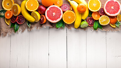 Fototapeta na wymiar Fresh citrus fruits. Lemon orange, tangerine, lime, banana. On a white background Wooden. Top view.