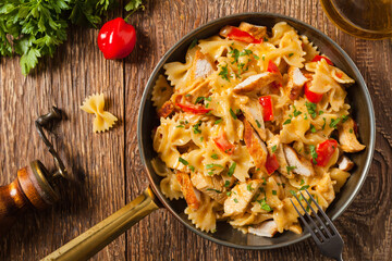 Pasta farfalle with chicken and paprika, in carbonara sauce.