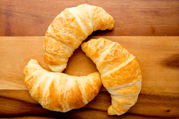 Croissants on wooden cutting board
