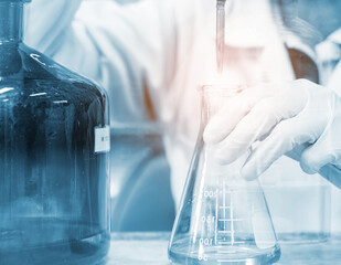 Scientist hand titration with burette and erlenmeyer flask, science laboratory research and...