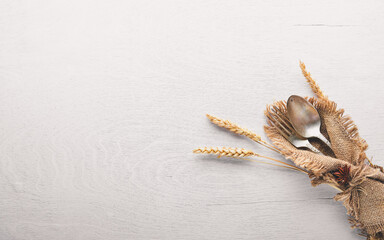 Cutlery, spoon and fork in old fabric on Wooden background. Top view. Free space.