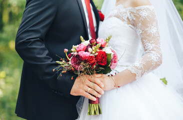 the bride and groom stand side by side and holding wedding bouquet