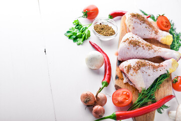 Fresh chicken thighs with cherry tomatoes, chili peppers, garlic and oil. Top view.
