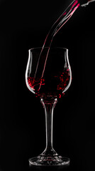 a glass of red wine which is poured on a black background