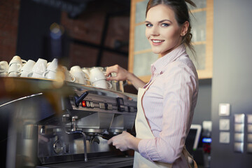 Fototapeta na wymiar Portrait of waitress making coffee