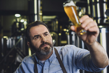 Brewery worker with glass of beer