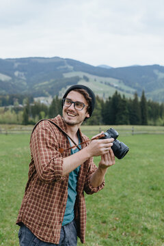 Man makes photos in mountains. Photographer. Traveler. Tourist. Boy looks at the camera.