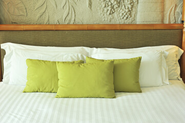 Comfortable white and green pillow on bed