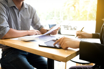 Fototapeta premium Teamwork process, Two business colleague meeting to discussing the new project business strategy plan with using digital tablet and calculator. Briefing, brainstorming, consulting