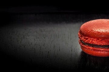 Sweet french macaroon or macaron on black wooden table. Space for text.