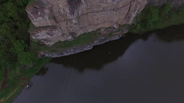 Rope jumping from high mountains, over the river