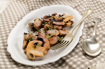 fried mushroom slices and thyme on a plate