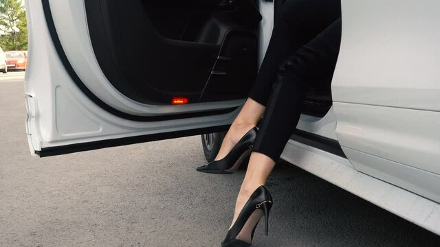 Women's heels come out of an expensive car