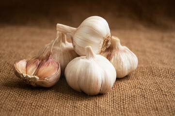 Garlic on cutting board , close-up on sacking. burlap background Copy space. Space for text.